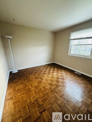 A room with wooden flooring and a window.
