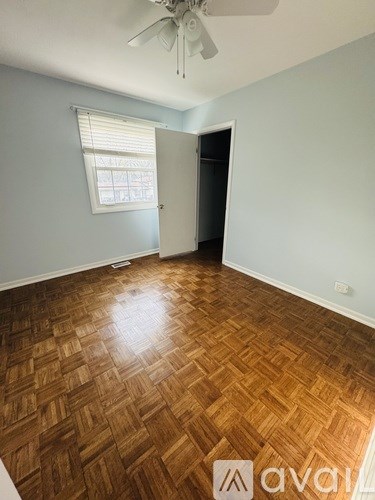 A room with wooden flooring and a ceiling fan.