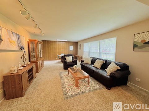 A living room with a black couch and a wooden coffee table.