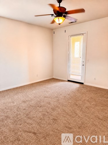 A room with a ceiling fan and a closed door.
