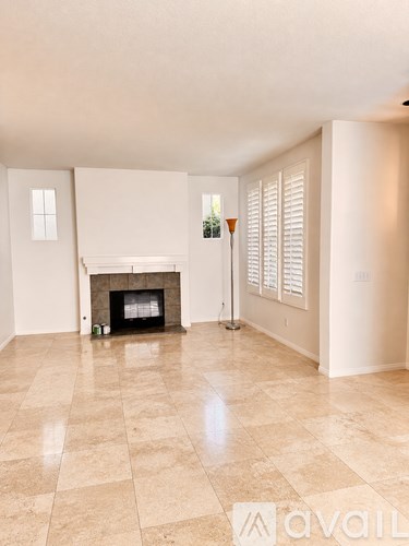 A living room with a fireplace and a tiled floor.