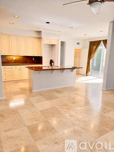 A kitchen with a marble floor and a ceiling fan.