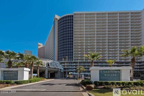 A large building with a glass facade and palm trees in front of it.