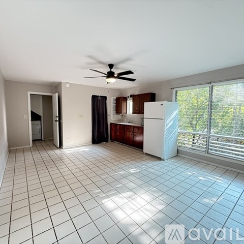 A kitchen with a white fridge and a ceiling fan.