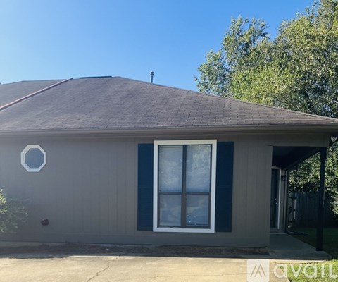 A house with a grey roof and a white window.