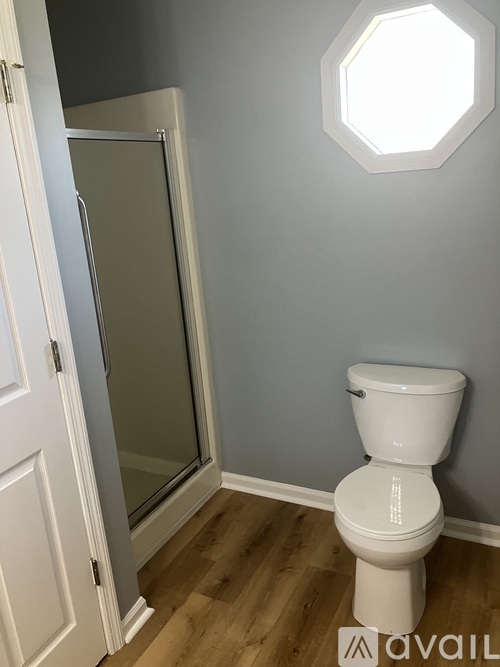 A white toilet in a bathroom with a glass shower door.