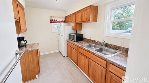 A kitchen with wooden cabinets and a granite countertop.