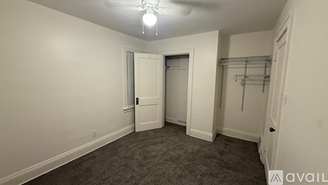 A room with a grey carpet and a white door.