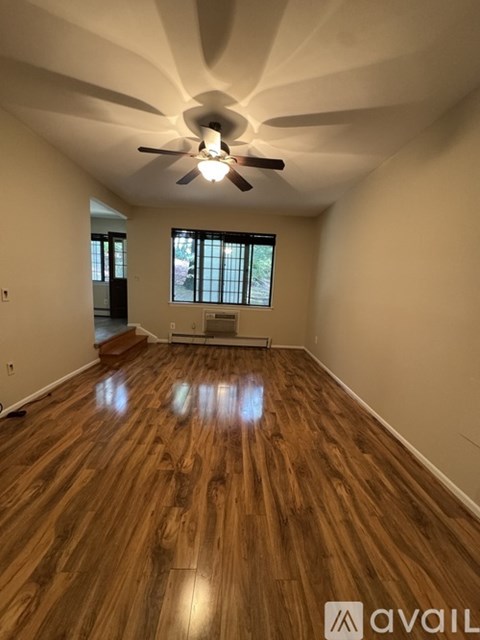 A room with wooden floors and a ceiling fan.