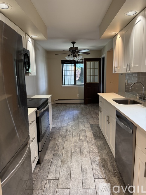 A kitchen with a tile floor and a ceiling fan.