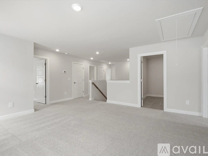 A spacious empty room with white walls and carpeted floor.