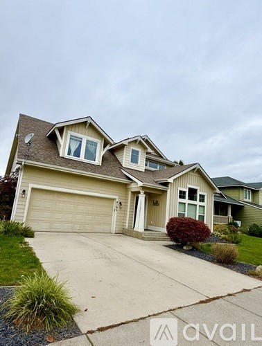 A two-story house with a garage and a driveway.
