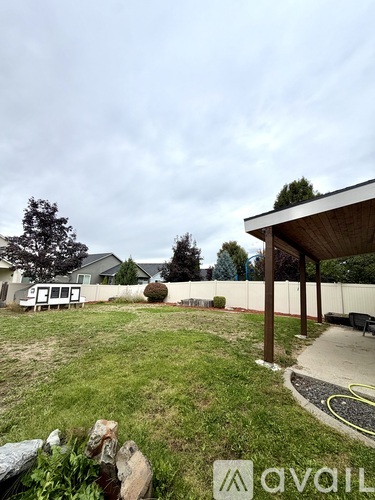 A backyard with a wooden structure and a tree.