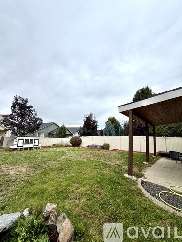 A backyard with a wooden structure and a tree.
