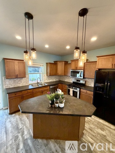 A kitchen with wooden cabinets and a black refrigerator.