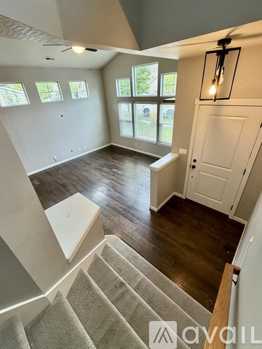 A well-lit, spacious room with a staircase leading to the upper floor.