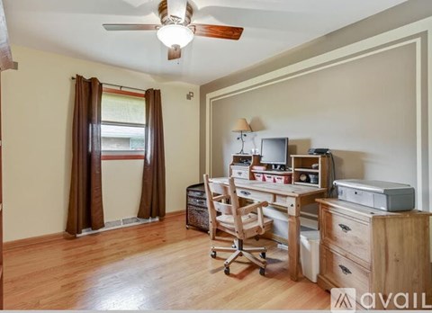 A room with a desk, chair, and printer.
