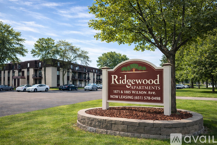 A sign for Ridgewood Apartments is displayed in front of a parking lot.