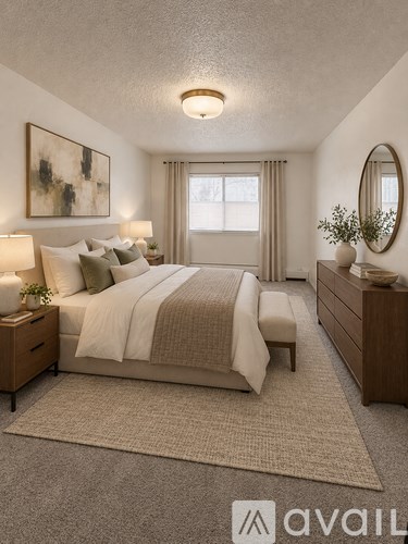 A bedroom with a large bed, a nightstand with a lamp, and a round mirror on the wall.
