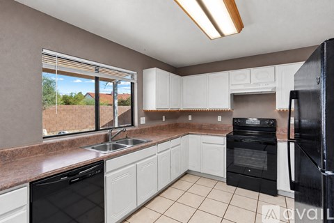 A kitchen with black appliances and white cabinets.