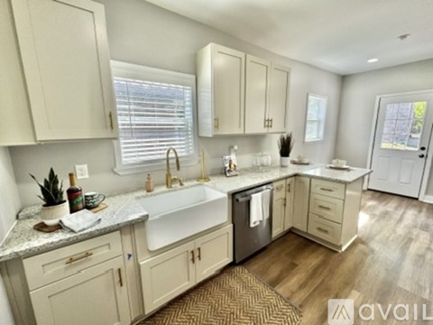 A kitchen with a sink, a window, and a rug on the floor.