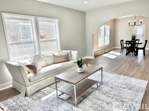 A modern living room with a white sofa and a glass coffee table.