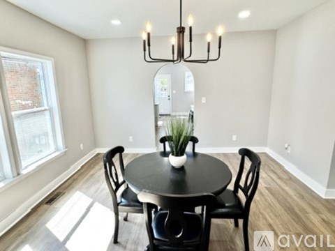 A dining room with a round table and chairs.