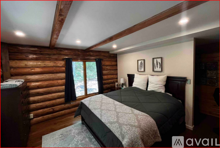 A bedroom with a large bed and wooden walls.