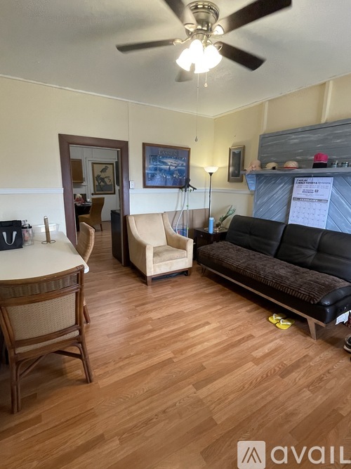 A living room with a black couch and a wooden table.