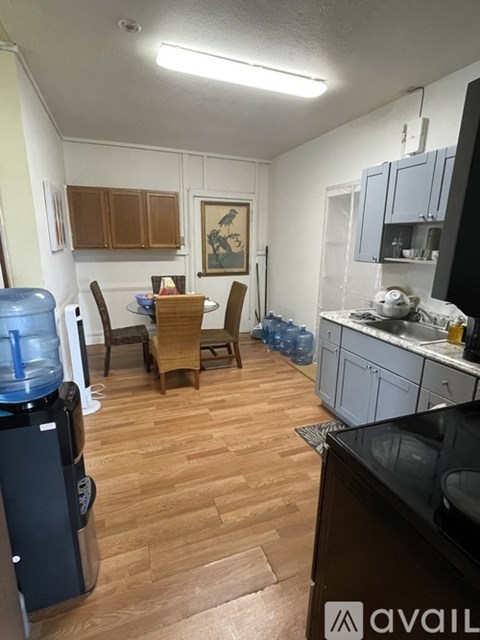 A kitchen with wooden floors and a dining table with chairs.