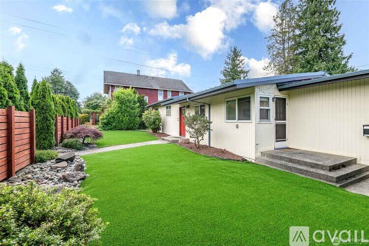 A house with a green lawn in front of it.