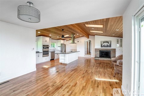 A modern kitchen with wooden floors and a fireplace.