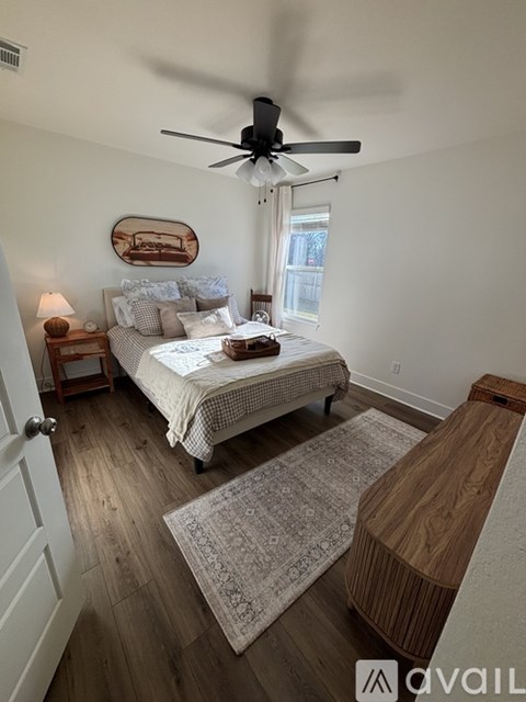 A bedroom with a bed, a ceiling fan, and a rug.