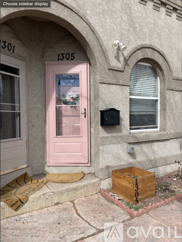 A pink door with a mailbox and a wooden box on the ground.