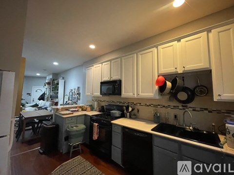 A kitchen with black appliances and white cabinets.