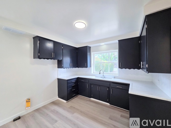 A kitchen with black cabinets and a window.
