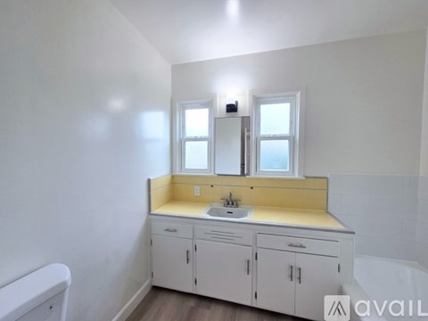A bathroom with a sink, mirror, and cabinets.