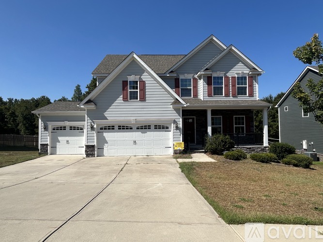 A two-story house with a garage and a driveway.