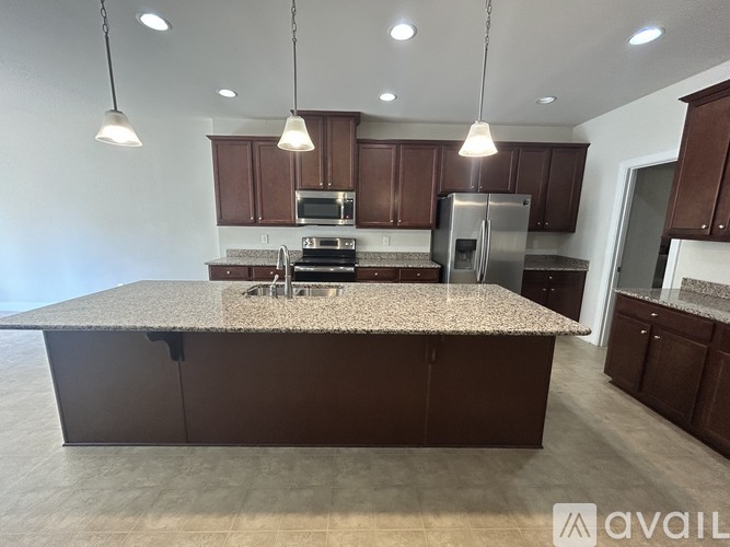A kitchen with brown cabinets and a granite countertop.