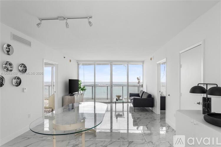 A modern living room with a glass table and a flat screen TV.