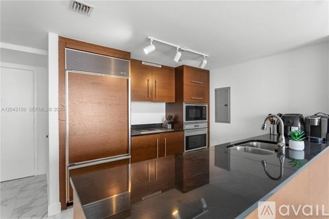 A modern kitchen with wooden cabinets and stainless steel appliances.