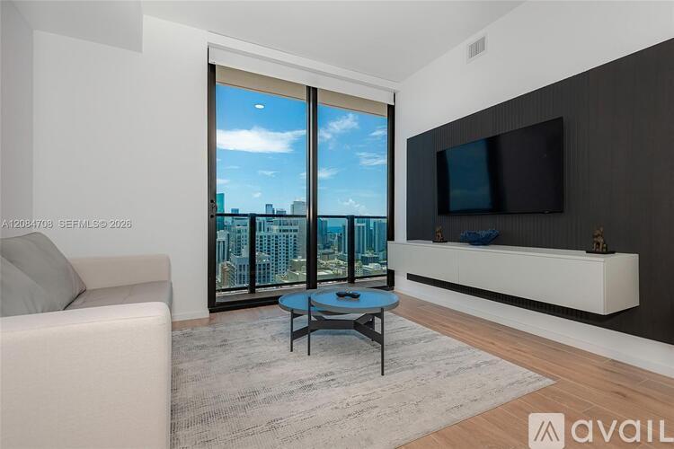 A modern living room with a large window overlooking the city.