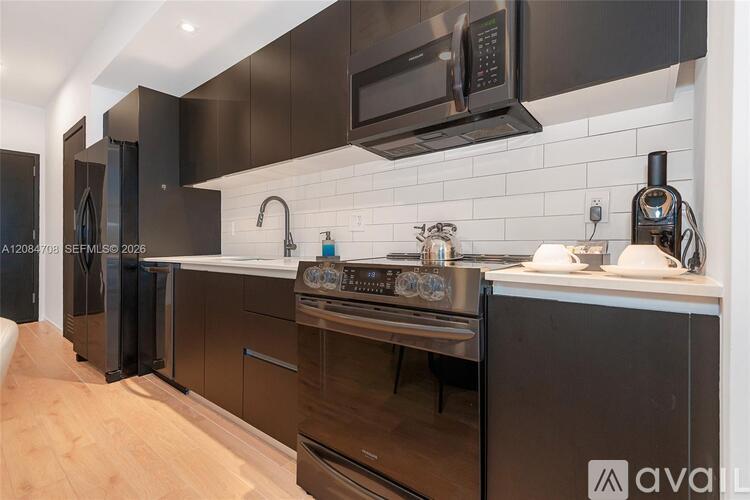 A modern kitchen with dark brown cabinets and stainless steel appliances.
