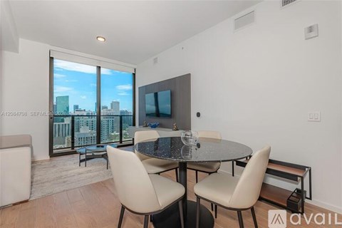 A modern dining room with a glass table and chairs.