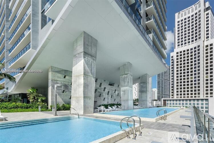 A modern building with a pool in the foreground.