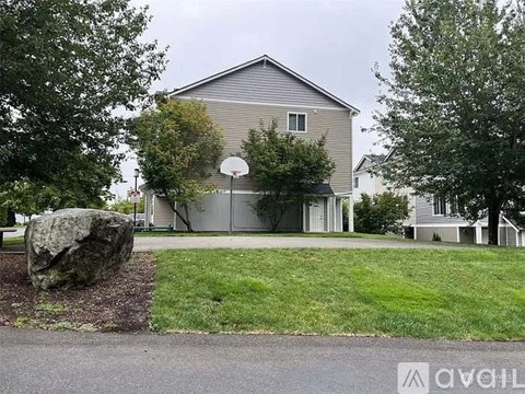 A house with a basketball hoop in the front yard.