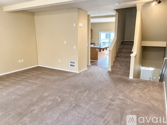 A spacious living room with a staircase leading to the upper floor.
