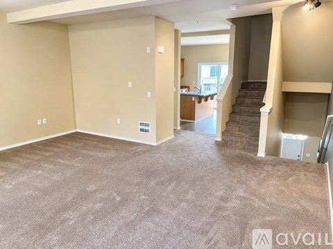 A spacious living room with a staircase leading to the upper floor.