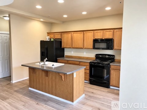 A kitchen with wooden cabinets and black appliances.