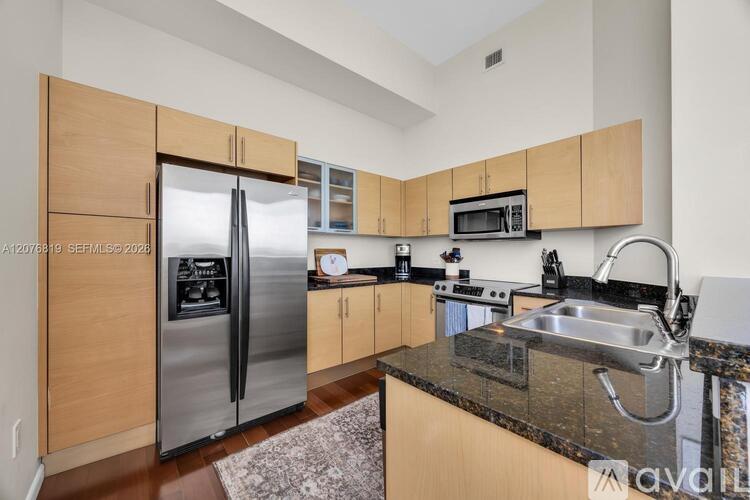 A kitchen with wooden cabinets and a granite countertop.
